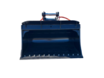 Front view of a large blue excavator bucket attachment on a concrete lot, with orange hoses and other equipment in the background.