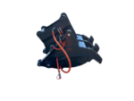 Close-up of a hydraulic excavator grapple attachment with black metal jaws and orange/red hoses.